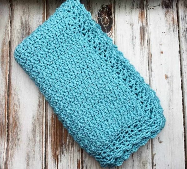Baby blanket shown with a pretty laced edging.