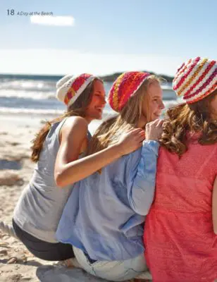 Three women wearing colorful crocheted summer hats.