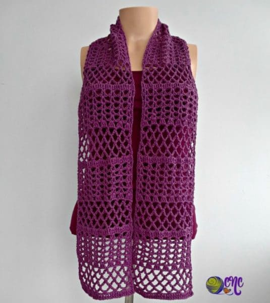 The lacy scarf is worn long on a mannequin. The free crochet pattern works up quick and easy.
