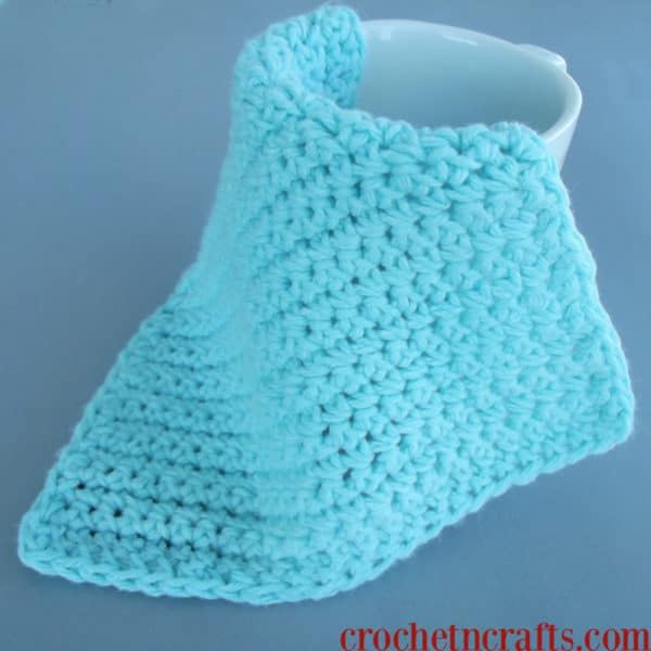 Beginner crochet dishcloth shown in a single color with single crochet stitches.