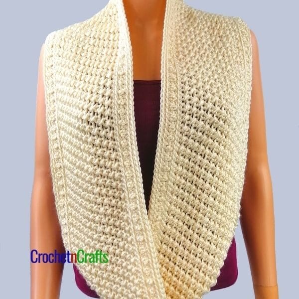 A beautifully textured crochet cowl worn long around the neck.
