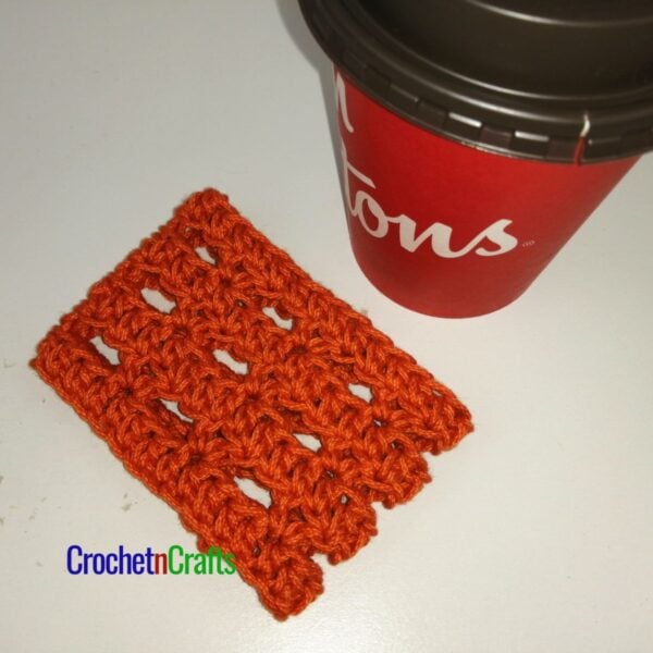 Simple and lacy crochet cup cozy laid flat.