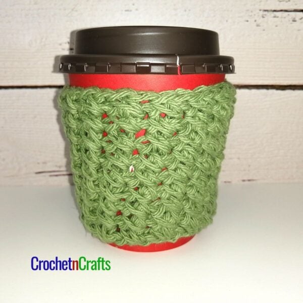 Crochet cup cozy pattern shown take-out coffee cup.