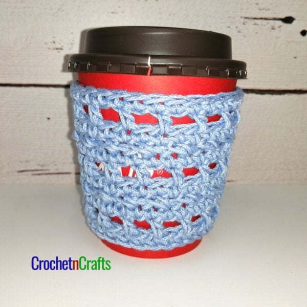Crochet cup cozy pattern shown on to-go cup.