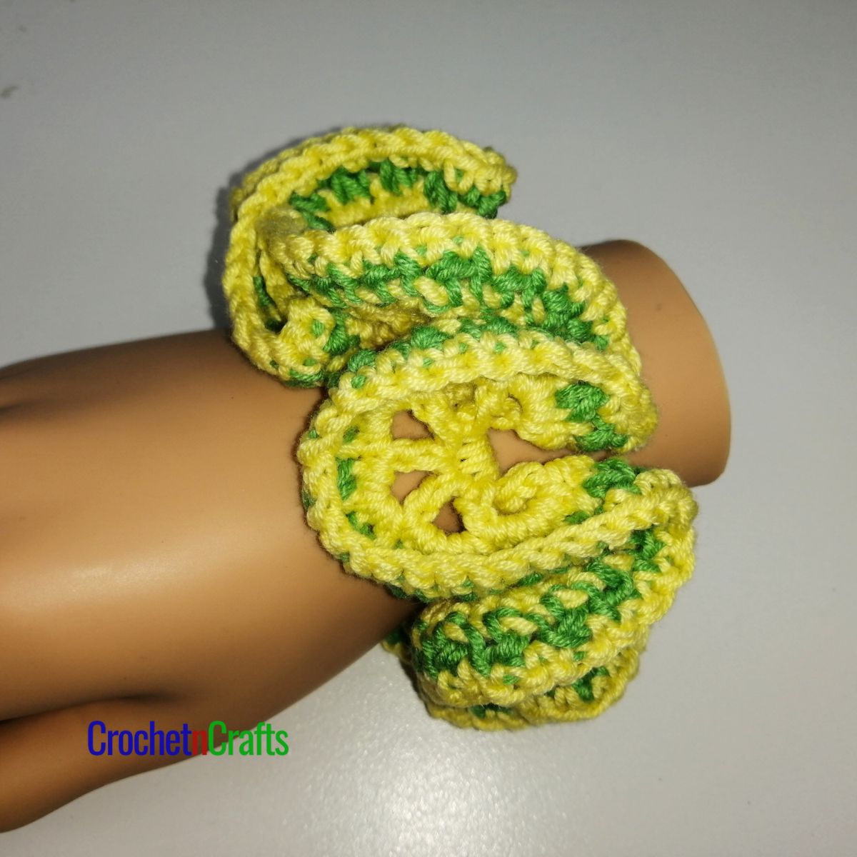 Crochet hair scrunchie shown in yellow and a stripe of green.
