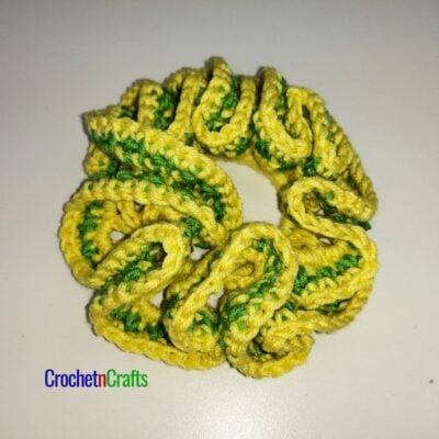 Crochet hair scrunchie shown in yellow and a stripe of green.