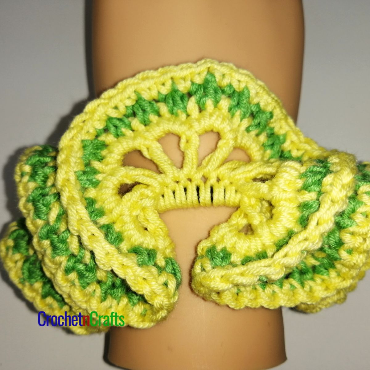 Crochet hair scrunchie shown in yellow and a stripe of green.