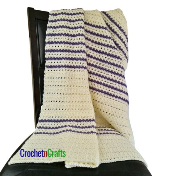 Crochet blanket draped over a chair.
