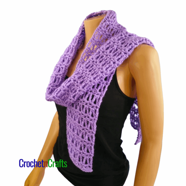 Crocheted scarf shown on a mannequin. Loosely draped over the shoulder.