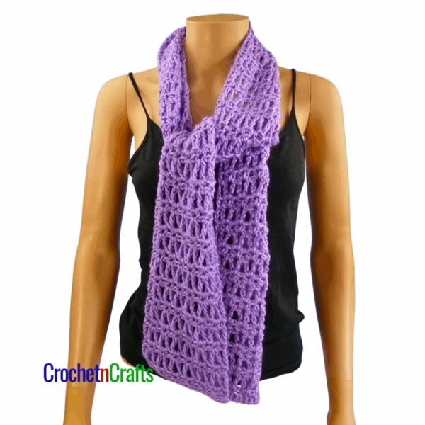 Crocheted scarf shown on a mannequin. Tied in a knot at the front.