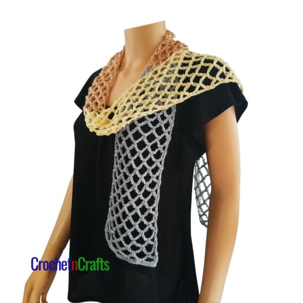 Crocheted mesh scarf pattern shown on a mannequin - draped over one shoulder - side view.