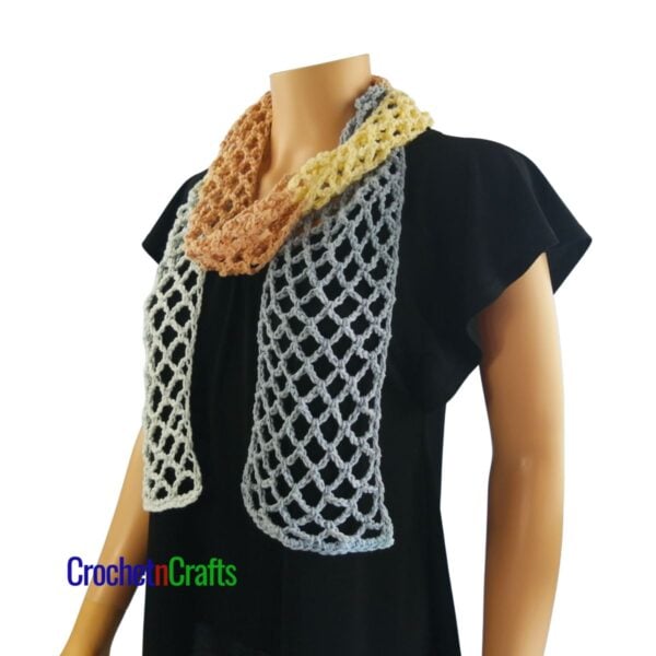 Crocheted mesh scarf pattern shown on a mannequin - wrapped around - side view.
