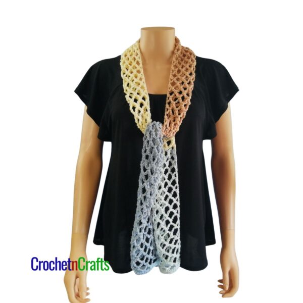 Crocheted mesh scarf pattern shown on a mannequin - tied at the front - front view.