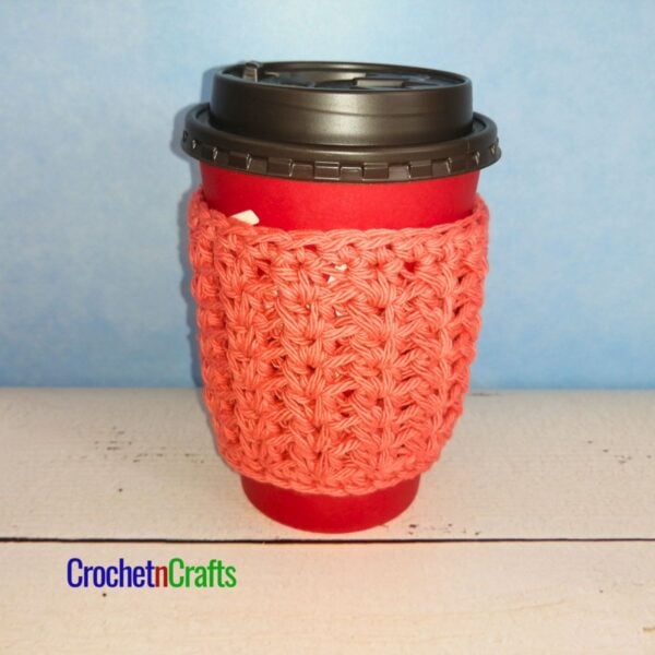 Crochet cup cozy shown on a take-out cup.