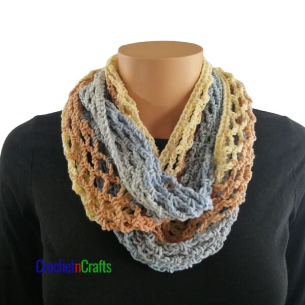 Crochet diamond mesh cowl worn cozy around the neck.