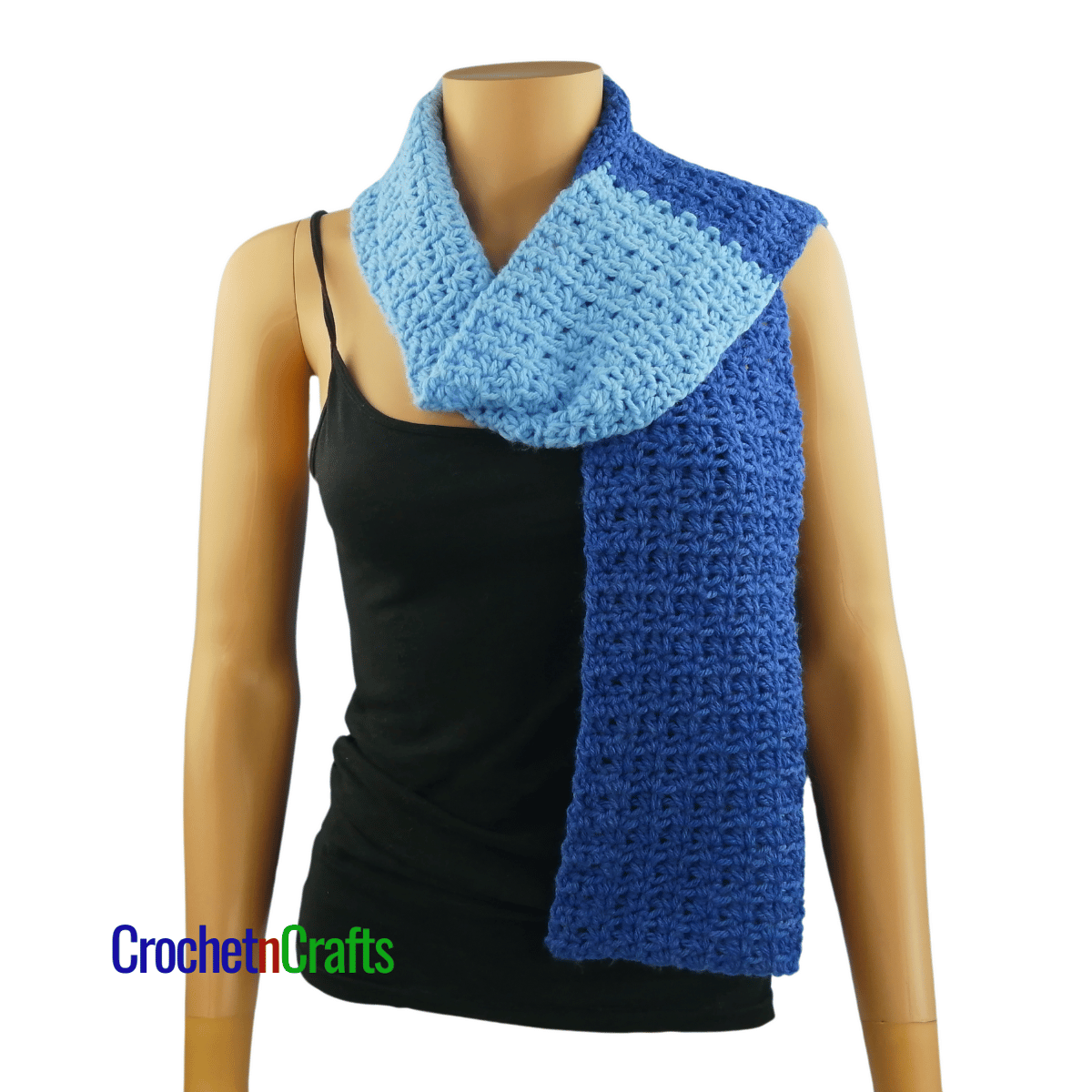 A crocheted scarf worn on the mannequin - draped over the shoulder.