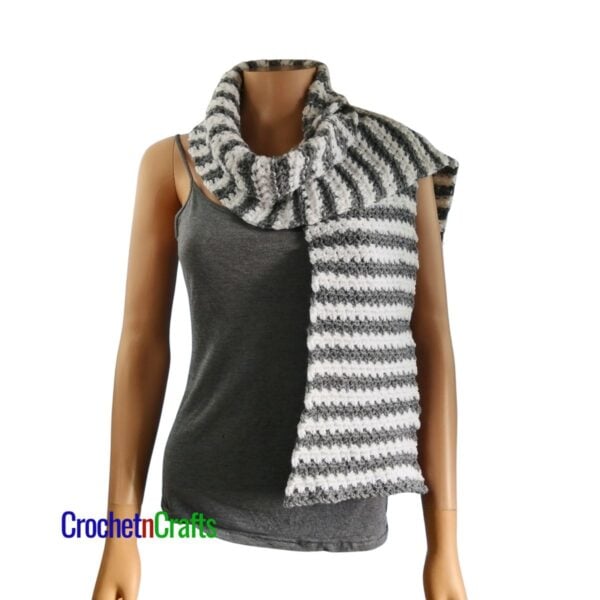 A striped crochet scarf draped over the shoulders.