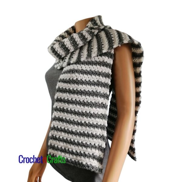 A crunch stitch striped crochet scarf draped over the shoulders - side view.