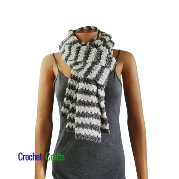 A striped crochet scarf folded and looped through at the front for a cozy neck scarf.
