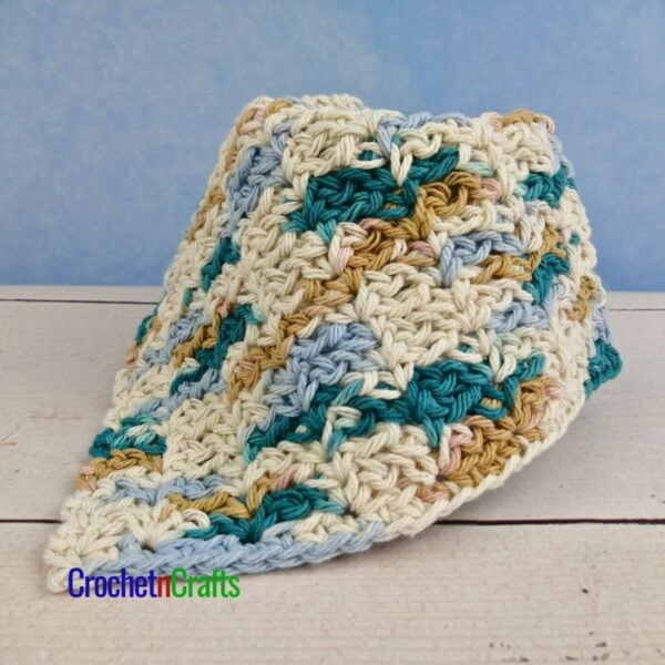 A crocheted dishcloth draped over a glass.