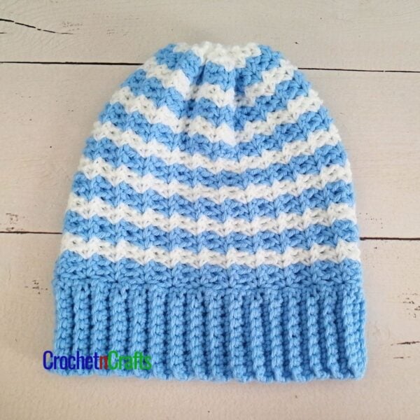 A Striped crocheted hat laid flat.