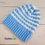 A Striped crocheted hat laid flat.