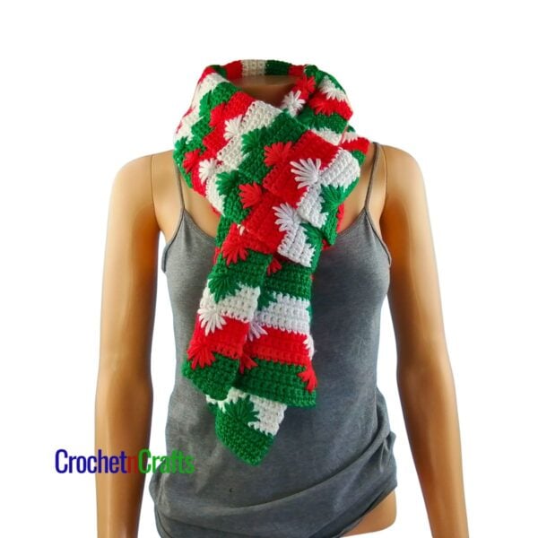 A Christmas crochet scarf folded and looped through for a cozy neck scarf.