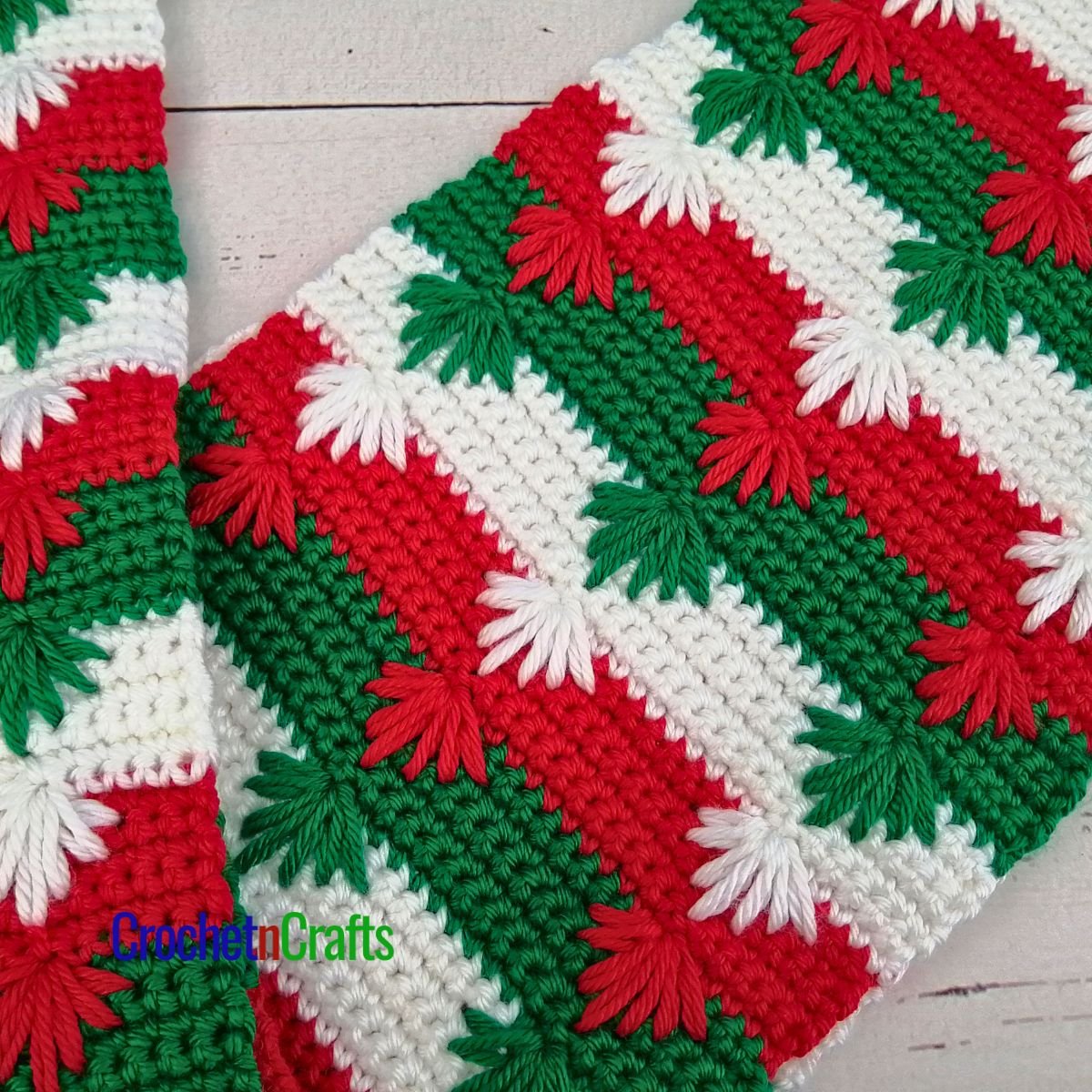 A Christmas crochet scarf laid flat.