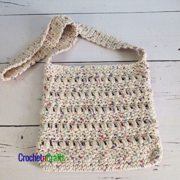 A small crocheted bag laid flat.