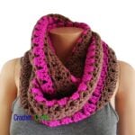 A crocheted cowl worn cozy around the neck.