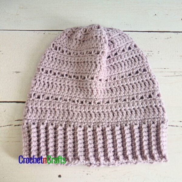 A simple crocheted hat laid flat.
