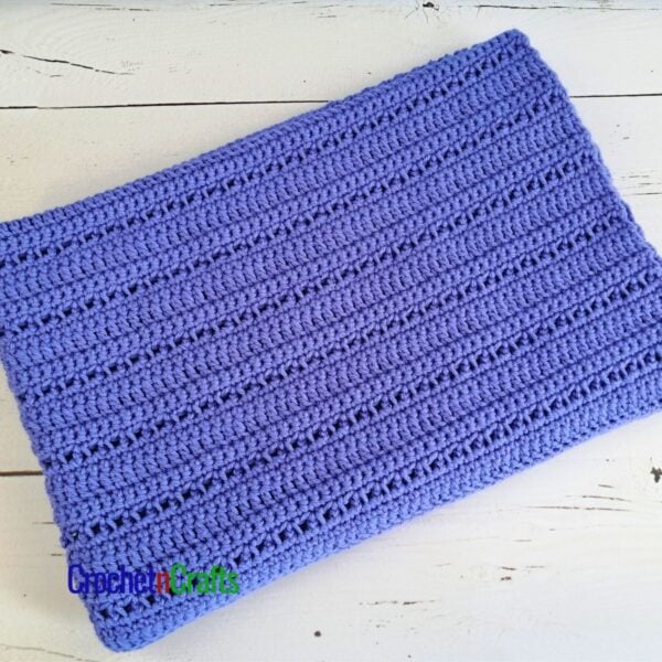 A crocheted lapghan folded up.