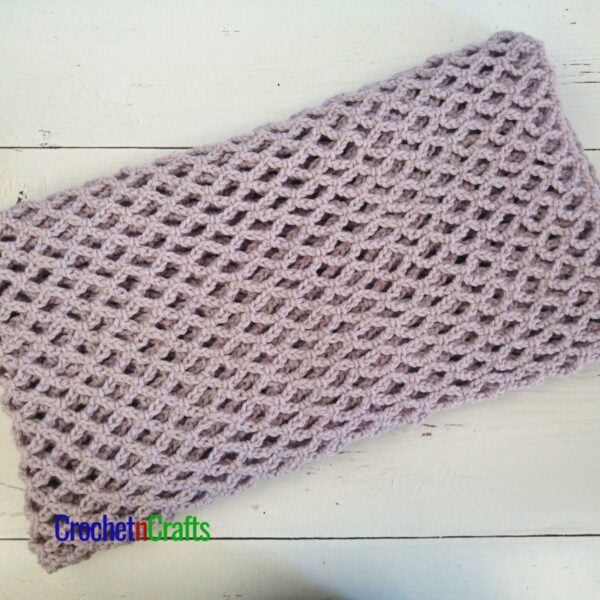 A crocheted mesh blanket folded up.