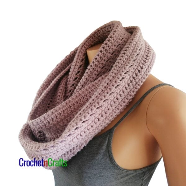 A crocheted cowl wrapped cozy around the neck of a mannequin.