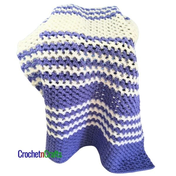A striped mesh blanket is draped over a stool.