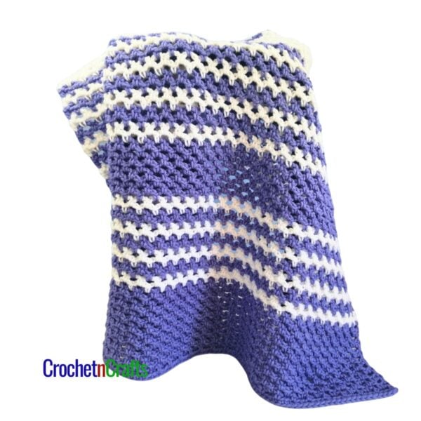 A striped mesh blanket is draped over a stool.