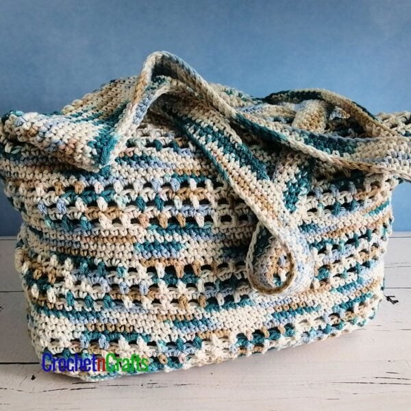 Crocheted tote bag sitting on a table.
