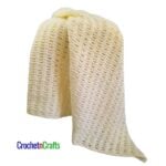 A crocheted blanket draped over a stool.