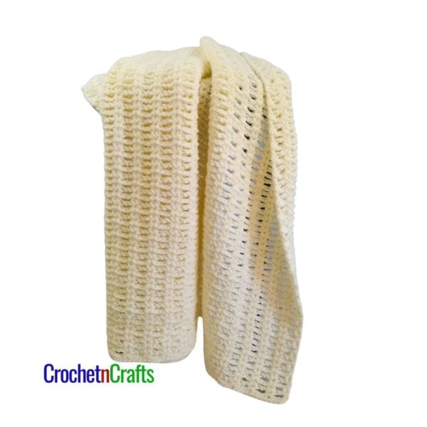 A crocheted blanket draped over a stool.
