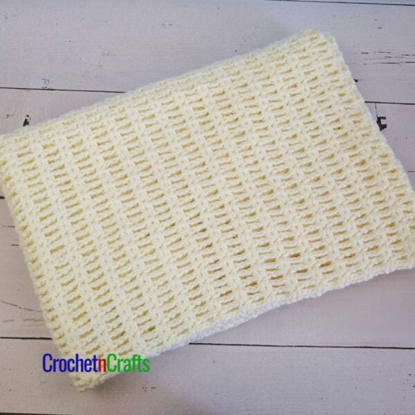 A crocheted blanket folded up.