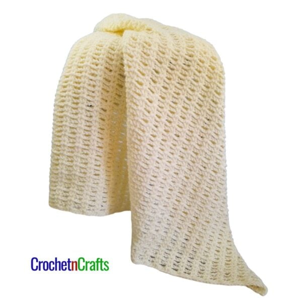 A crocheted blanket draped over a stool.