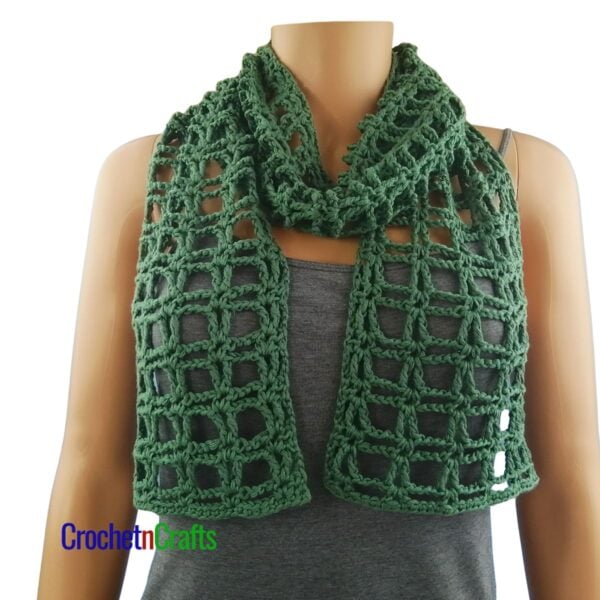 A light summer crochet scarf wrapped loosely around the neck.