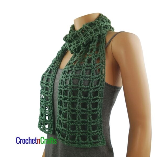 A light summer crochet scarf wrapped around the neck.