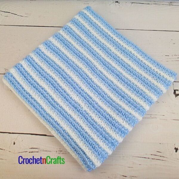 Striped crochet baby blanket laid flat.