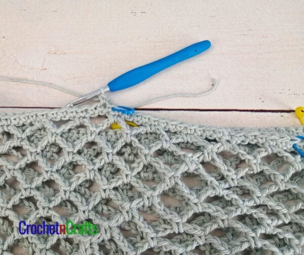 Join yarn to the left of the stitch marker on the left, leaving the 20 stitches in the middle unworked.