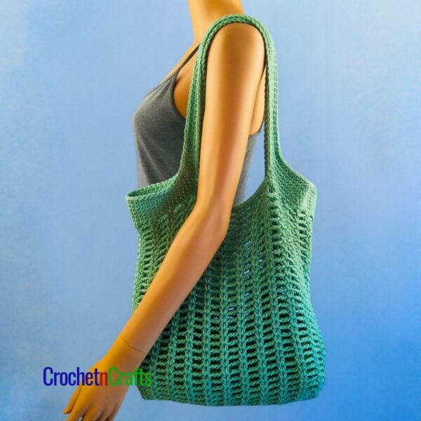 Pretty Simple Chains Crocheted Shoulder Bag Over the Shoulder of a Mannequin.
